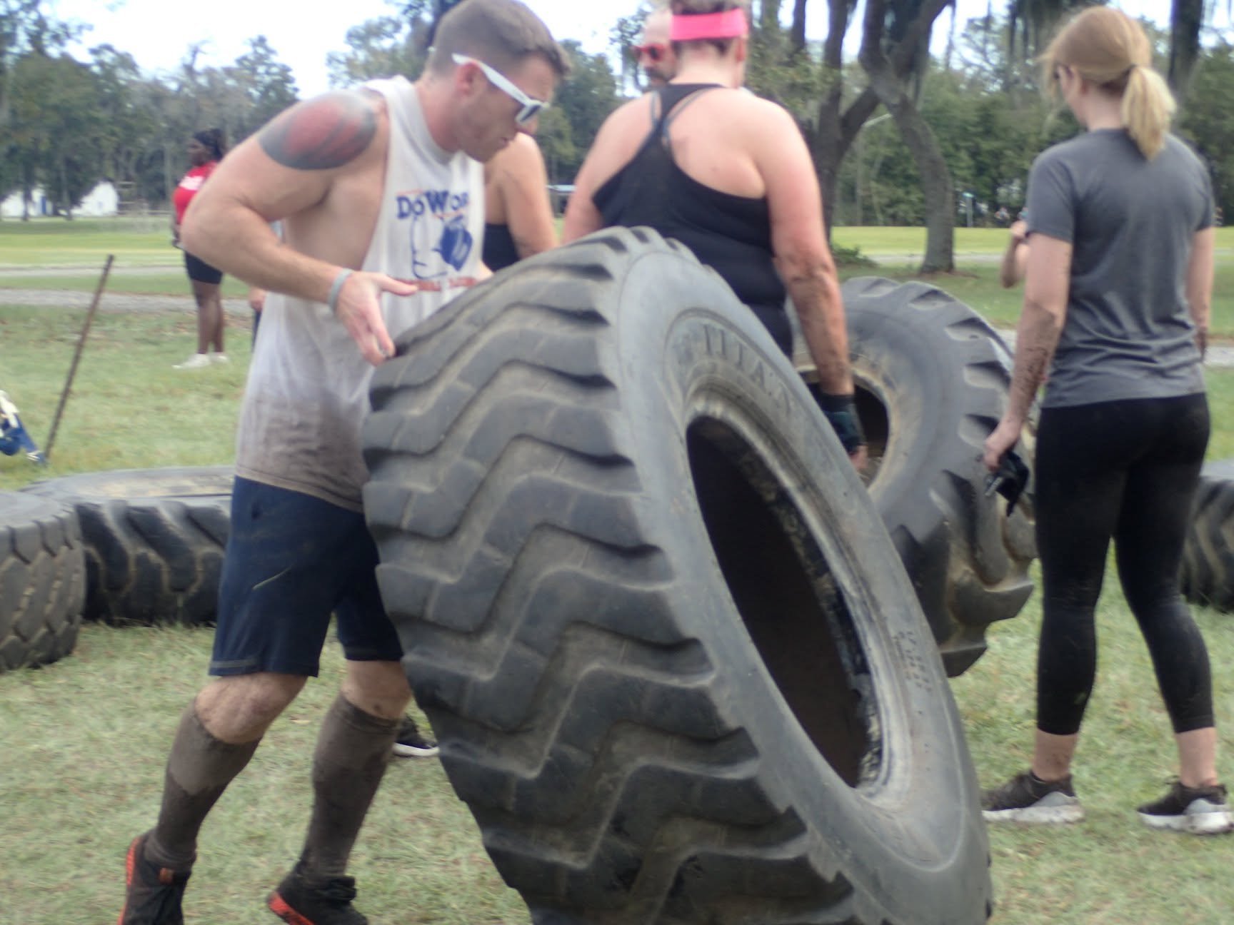 Coach flipping a tractor tire during a team training event